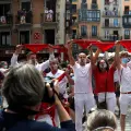 Revellers hold up traditional red scarves in front of the town hall where the firing of "chupinazo", which opens the San Fermin festival that was cancelled due to the coronavirus disease (COVID-19) outbreak, should have taken place, in Pamplona, Spain July 6, 2020. REUTERS/Jon Nazca [[[REUTERS VOCENTO]]] HEALTH-CORONAVIRUS/SPAIN-BULLS