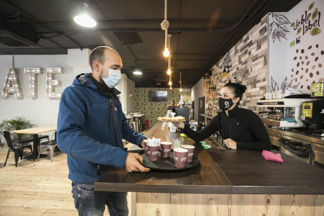 Javier Oliván, dueño del Late Gastrobar, sirviendo consumiciones en vasos de cartón.