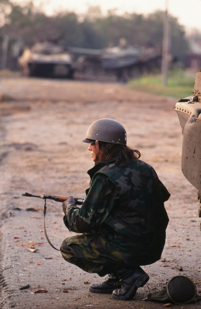 Soldado croata vigila su posición ante carros de combate destruidos al fondo