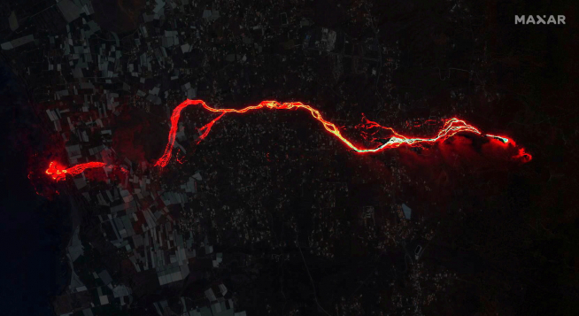 A composite image shows a satellite image of the lava flow from the Cumbre Vieja volcano overlaid on an earlier daytime satellite image
