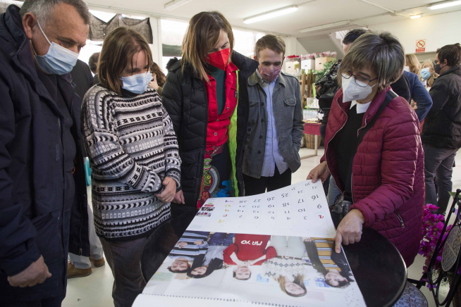 Los asistentes del acto observan el calendario de Atades.