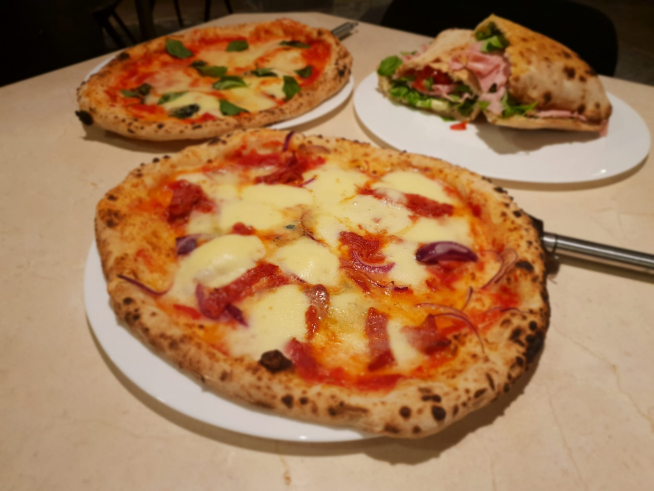 Pizza Leone, en primer plano, junto a una Margarita y el bocadillo Francesco Totti.