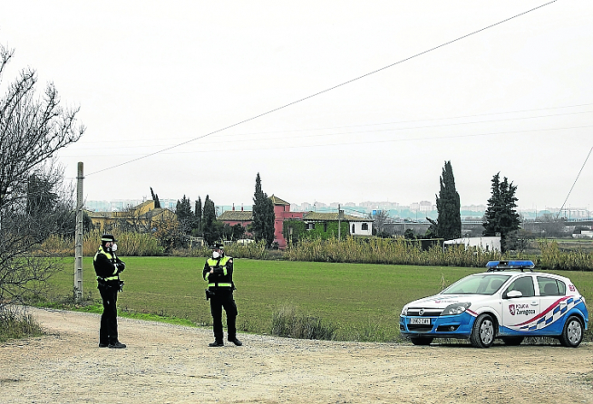 Dos policías vigilan la entrada a una urbanización en Movera.