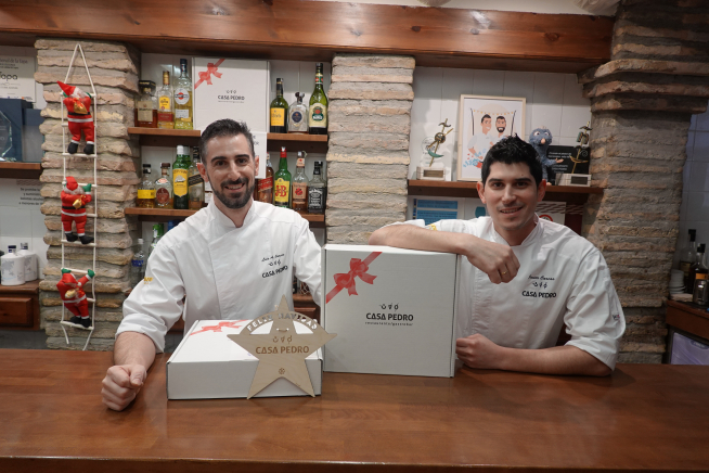 Los hermanos Carcas, con las cajas que guardan los elaborados platos de Casa Pedro.