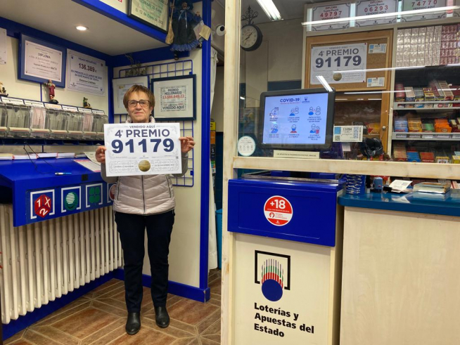 María Jesús Porté, from the Benasque tobacconist, shows the number of the 4th prize, of which she has sold a tenth.