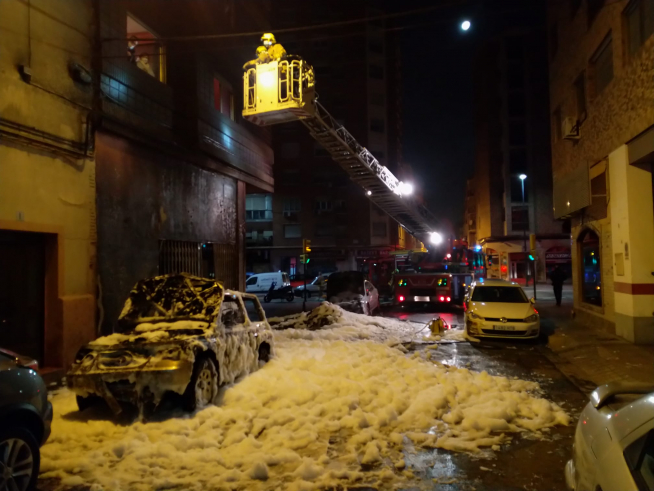 Labores de extinción del incendio causado al arder cuatro contenedores en la calle San Antonio Abad.