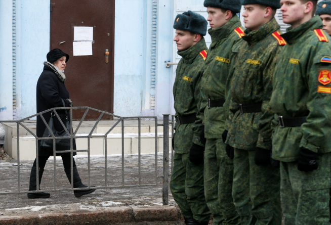 Una mujer pasa junto a los cadetes de la autoproclamada República Popular de Donetsk en la ciudad de Donetsk, controlada por los rebeldes.