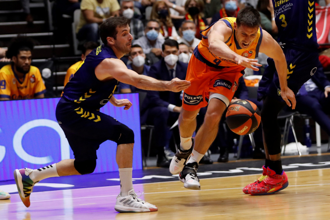 El base belga del Valencia Basket, Sam Van Rossom (d), bota el balón ante la defensa del base del Ucam Murcia Tomás Bellas (i) durante el partido de cuartos de final de la Copa del Rey.
