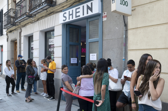 Varias personas hacen cola para entrar en la tienda de Shein en Madrid.