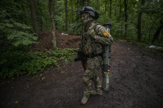 El soldado Vinin carga con un lanzagranadas cerca de una trinchera en medio de un bosque en Ucrania.