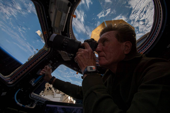 Larry Connor tomando fotografías de nuestro planeta desde la cúpula de la Estación Espacial Internacional.