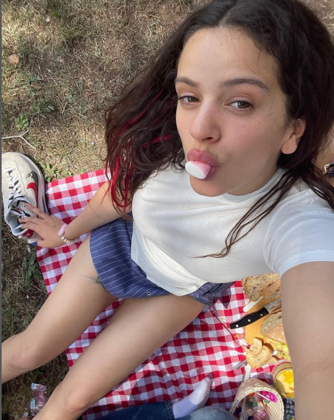 Rosalía, comiéndose una chuche en el picnic.