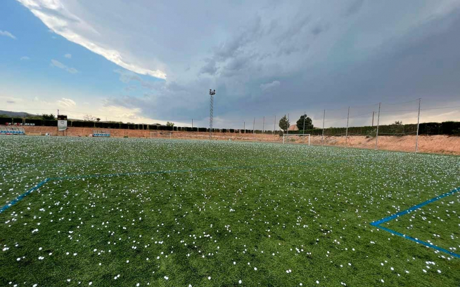 El campo de fútbol, cubierto de bolas de hielo blancas.