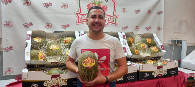 Adrián Mené muestra uno de los ejemplares de melón que venden en la empresa familiar.