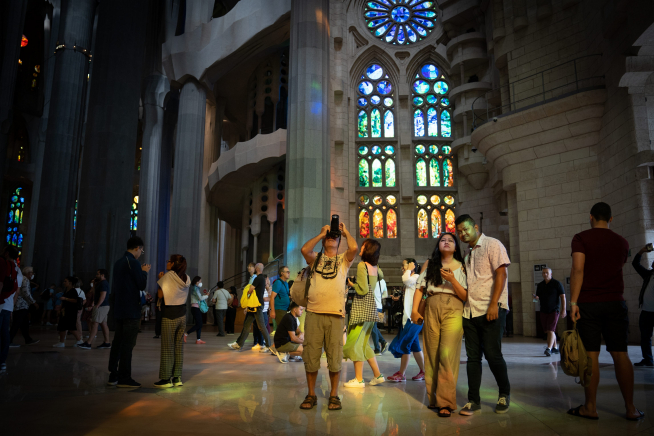 Turistas visitan y fotografían la Sagrada Familia en Barcelona.