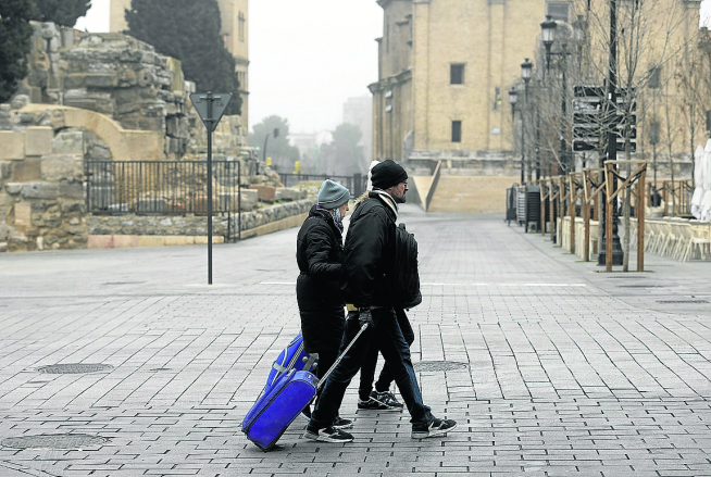 Varios turistas, ayer, con sus maletas por el centro de Zaragoza
