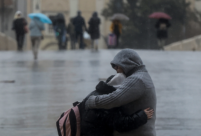 Una pareja se abraza mientras llueve, a 6 de febrero de 2023, en Valencia,