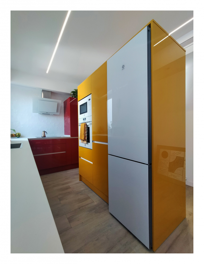 Una cocina de una casa de Zaragoza que utiliza como colores primarios el rojo, amarillo y azul.