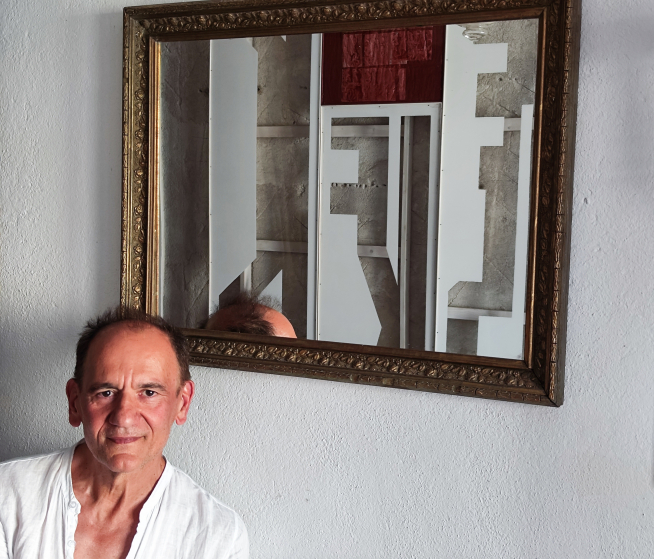 Santiado Arranz en su domicilio en Castejón de Sos. El espejo devuelve una de sus piezas de geometría y símbolos en las que tanto le gusta trabajar.