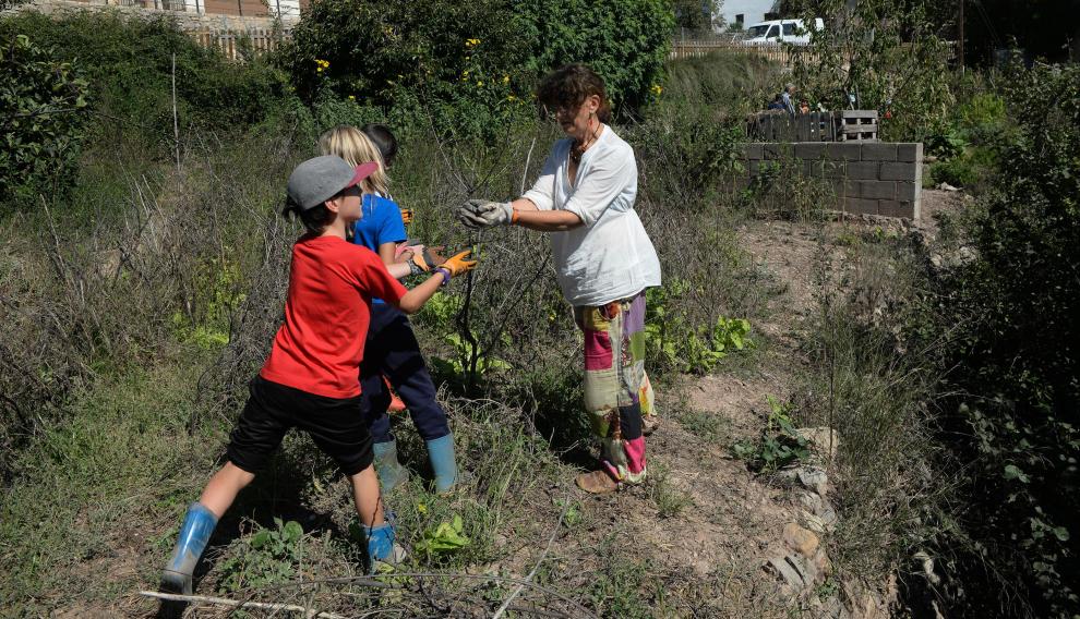 Delfi Ruiz, en el huerto de la escuela de Olba (Teruel), con tres de sus alumnos