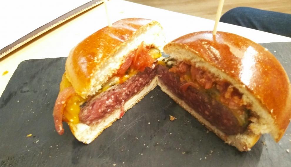 Hamburguesa de vacuno mayor con encurtidos y queso cheddar.