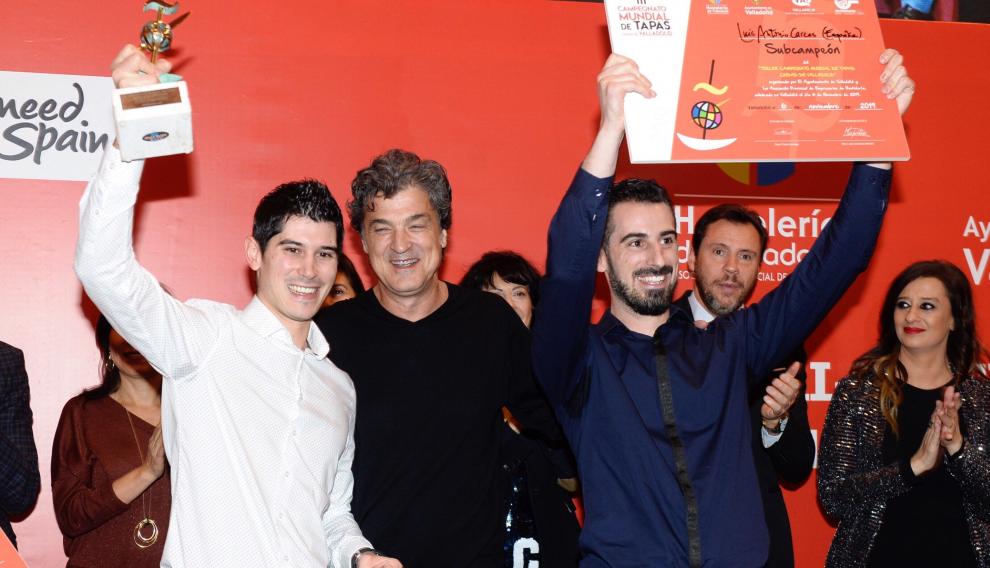Luis Carcas alza el diploma que le acredita como subcampeón (d), y su hermano Javier (i), el trofeo.