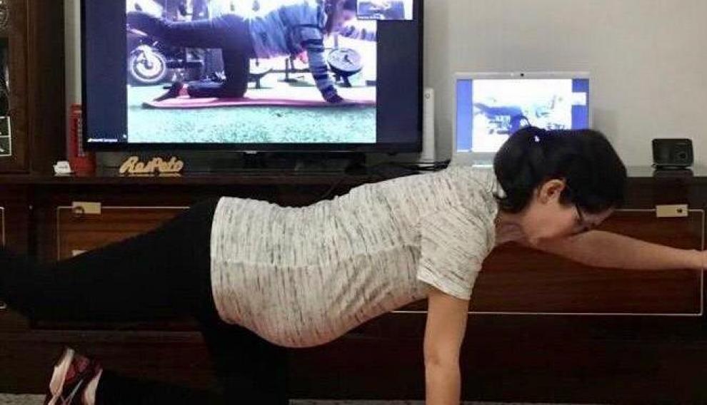 Una mujer embarazada realiza clases telemáticas para cumplir con el confinamiento.