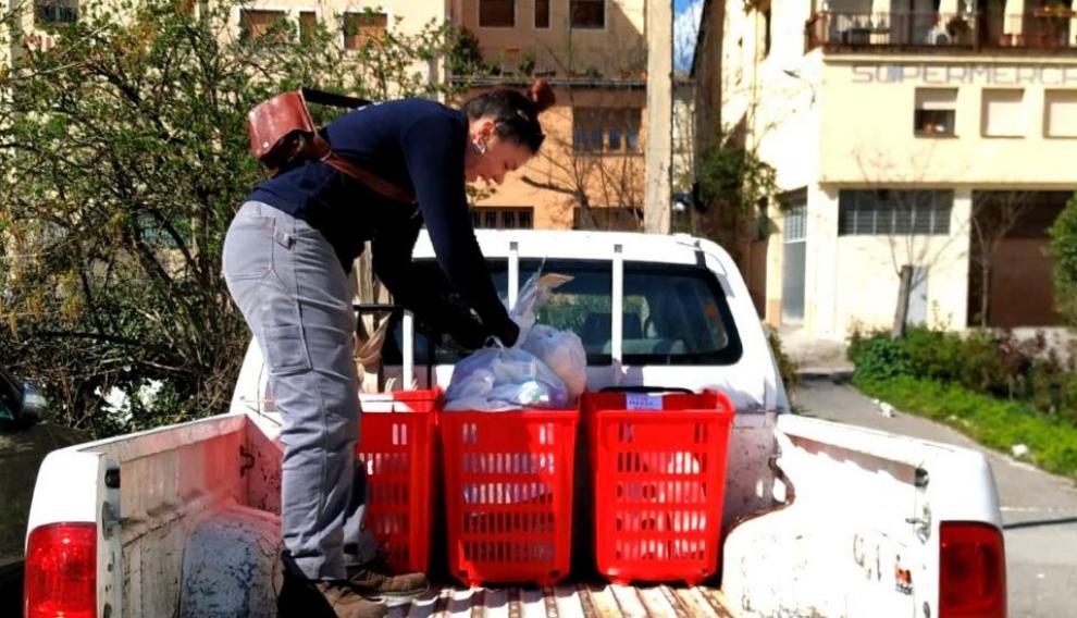 Una empleada municipal reparte alimentos en Aínsa.