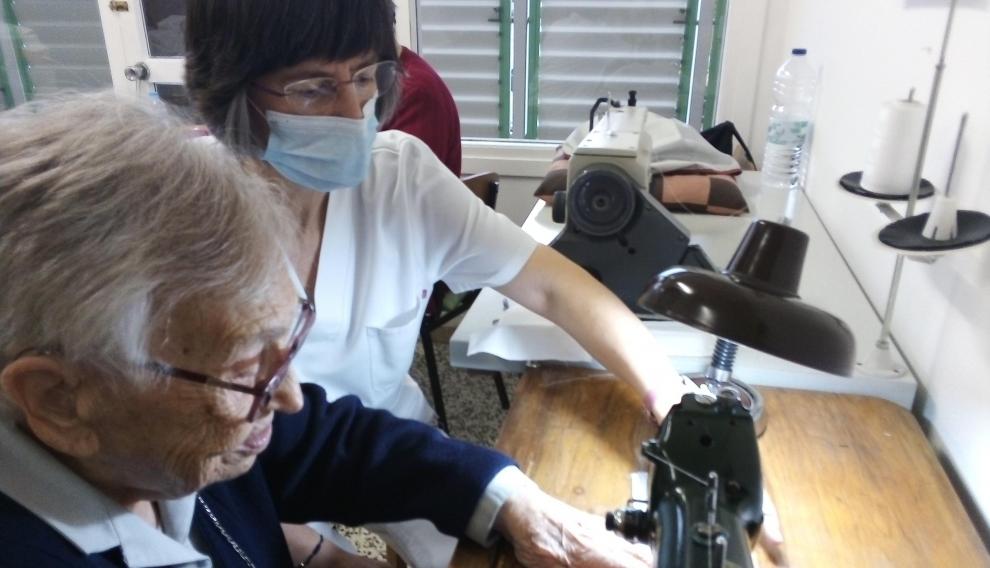 La hermana Milagros y la enfermera Milagrosa, a la máquina de coser.