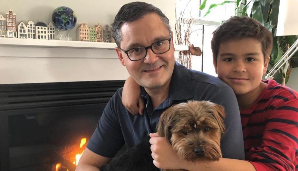 Santiago Comella junto a su hijo pequeño y su perro en su vivienda de Boston.