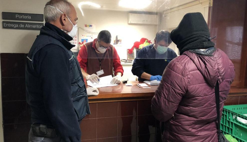 Trabajadores de El Refugio reparten lotes de comida a personas en situación de pobreza crónica.