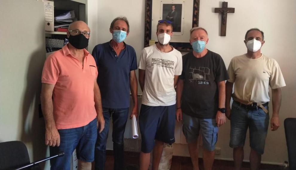 Ángel Modrego, a la izquierda, con el alcalde de Pomer y el resto de nuevos vecinos