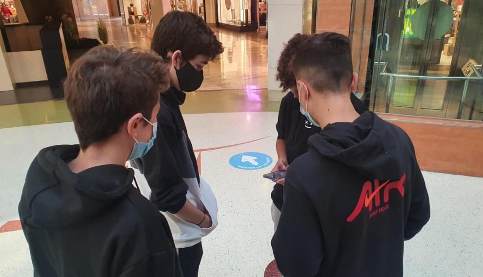 Un grupo de adolescentes pasa el día de clase no presencial en el centro comercial.