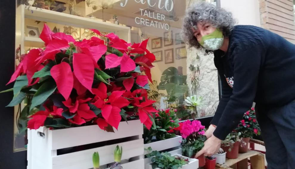 Ruth Albero arregla unas flores en la puerta de Artefacto, en la calle de San Pablo.
