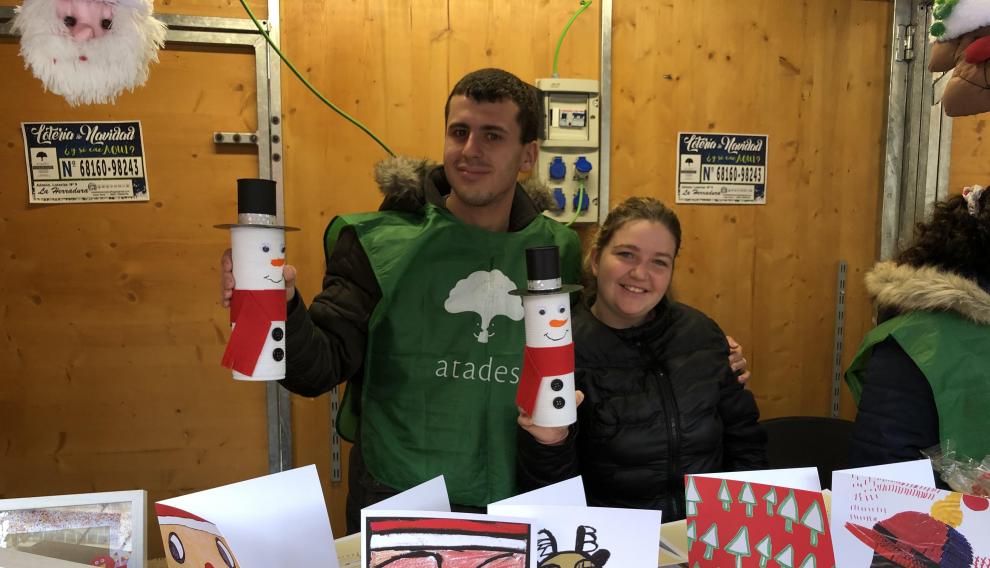 Dos alumnos del colegio de educación especial Atades–San Martín de Porres en una de las casetas del mercadillo navideño de 2019.