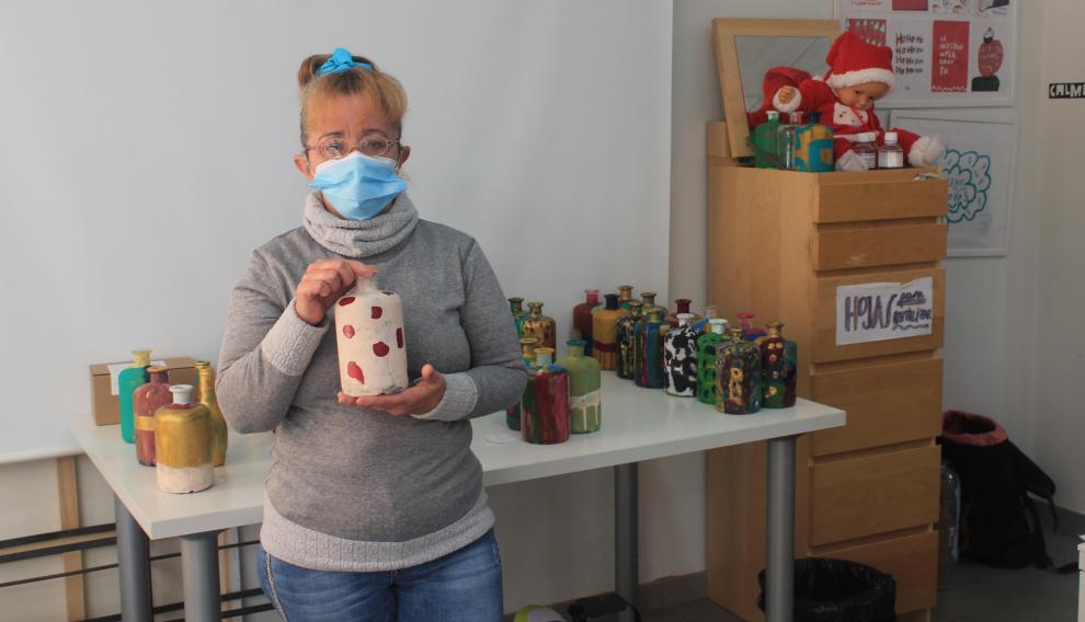 Cristina García, usuaria de Atades, enseña una de las botellas que ha decorado estos días.
