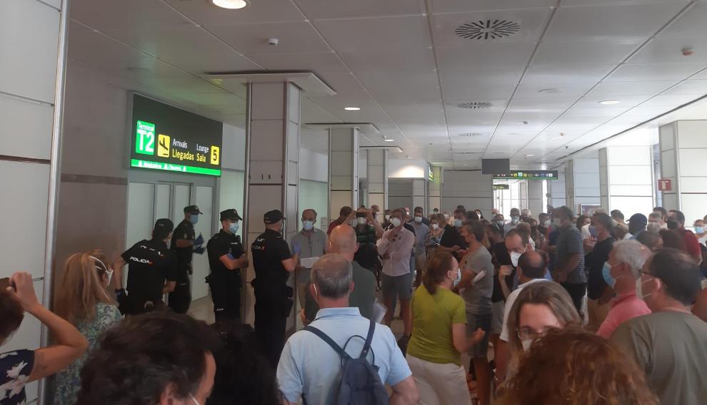 Los padres esperan en el aeropuerto de Madrid-Barajas la llegada de sus hijos desde Malta.