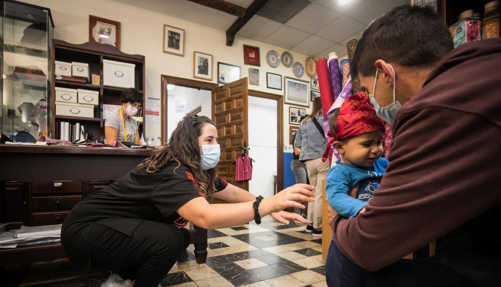 Asier, con sus padres, en Indumentaria San Jorge, donde le han hecho el traje