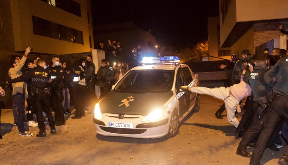 Varias personas rodean el coche en el que va el presunto asesino del niño.