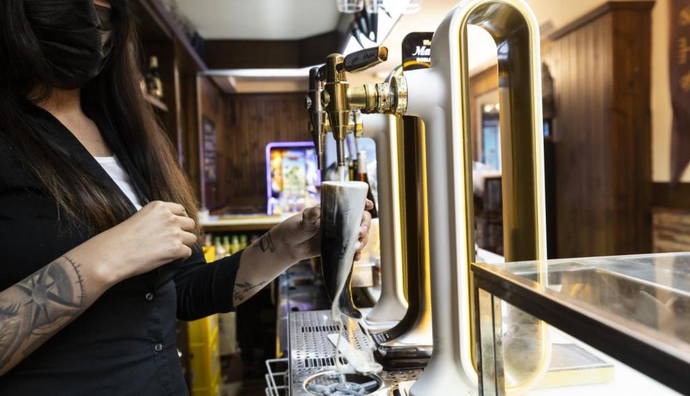 Alejandra Dávila, tirando la cerveza en un cuerno.