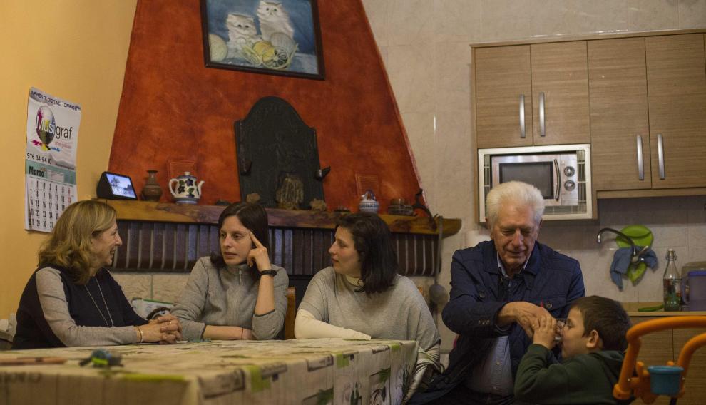 Feli, Morska y Olena hablan sentadas a la mesa mientras Julio atiende a Misa