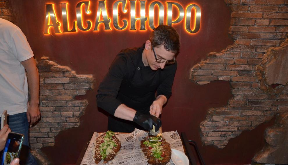 Un cocinero, rallando trufa negra en uno de los cachopos.