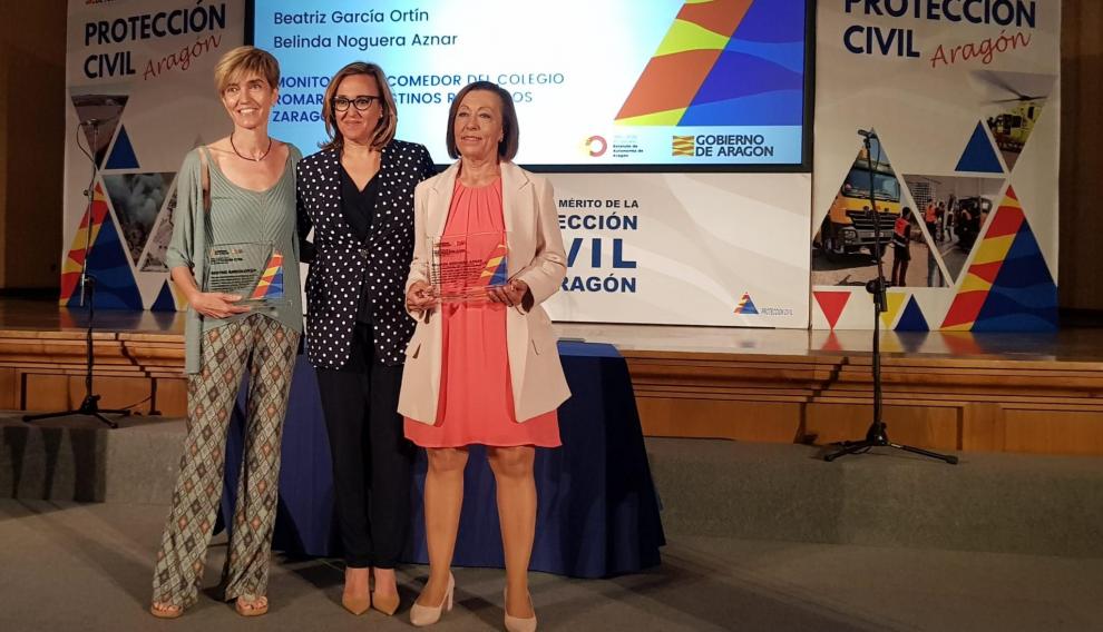 Beatriz García, Mayte Pérez y Belinda Noguera, ayer en la entrega del galardón a las monitoras del comedor del colegio Romareda que socorrieron a una niña que se atragantó con un gajo de naranja