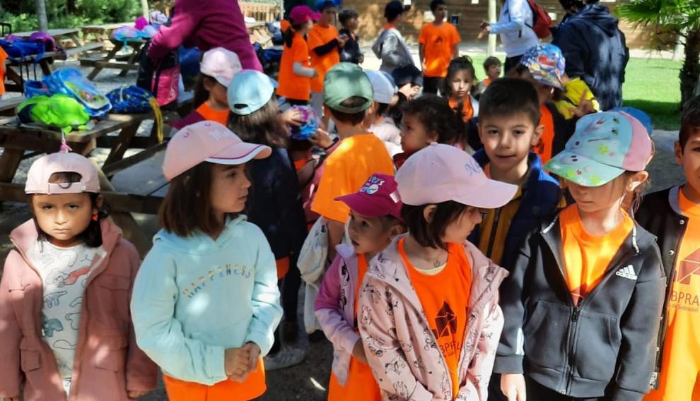 Algunos de los escolares más pequeños esperan en el parque la llegada de los autobuses para ser evacuados