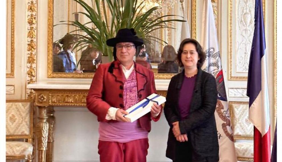 El alcalde de Fuendetodos, Enrique Salueña, vestido de goyesco, con la teniente de alcalde de Burdeos, Celine Papine, en la sede del Ayuntamiento de la capital de Nueva Aquitania.