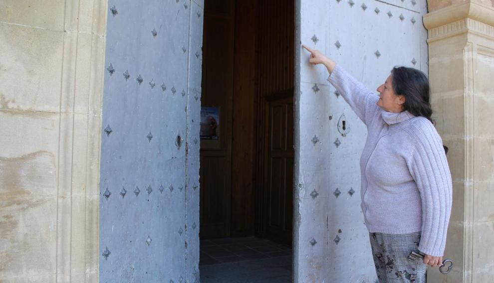 Lourdes Sarvisé muestra las marcas en la puerta de la iglesia.