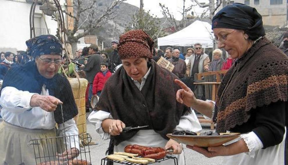 Un grupo de mujeres de la Festa del Tosino de Albelda muestran algunos de los productos del cerdo.