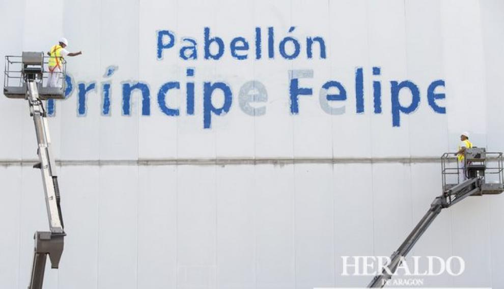 Comienzan los trabajos de borrado del letrero del pabellón Príncipe Felipe de Zaragoza a pesar de la suspensión cautelar dictada por el juez sobre el cambio de nombre. La imagen corresponde al 1 de octubre en la que dos pintores ayudados por plataformas elevadoras comenzaron a borrar las letras del pabellón.