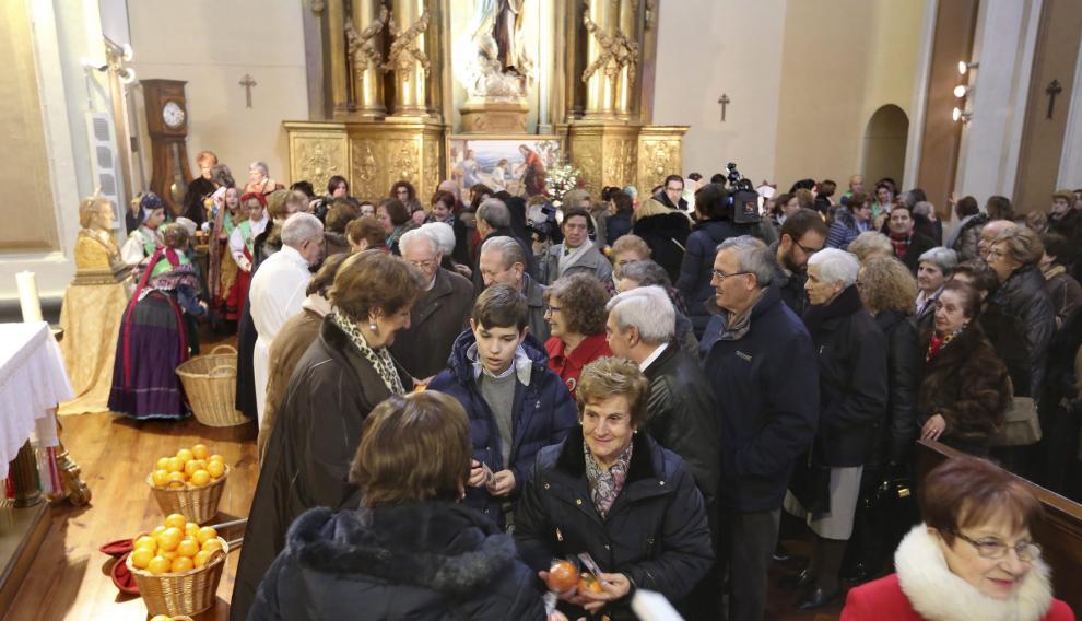 Los fieles pasaron a recoger sus naranjas bendecidas al término de la misa