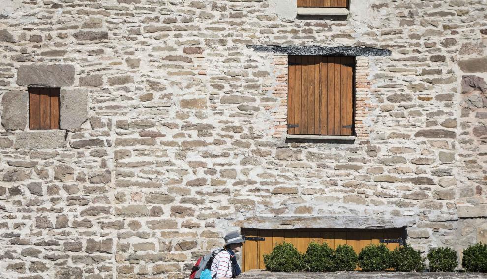 Una peregrina del Camino de Santiago se funde con el paisaje urbano de Undués de Lerda.